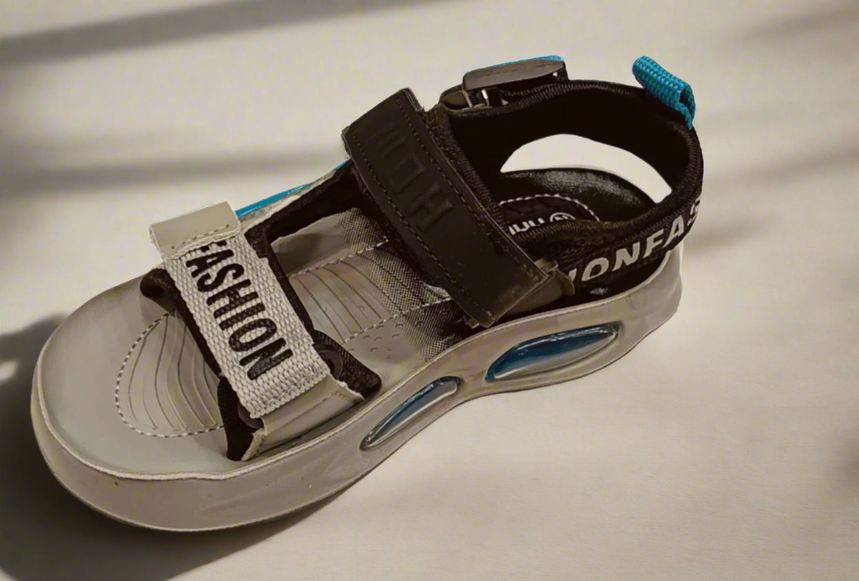 Beige sandal with black straps and 'Fashion' label on a white background