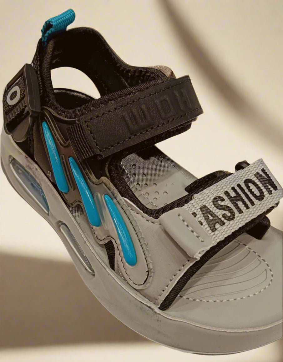 Beige sandal with black straps and blue accents on a white background