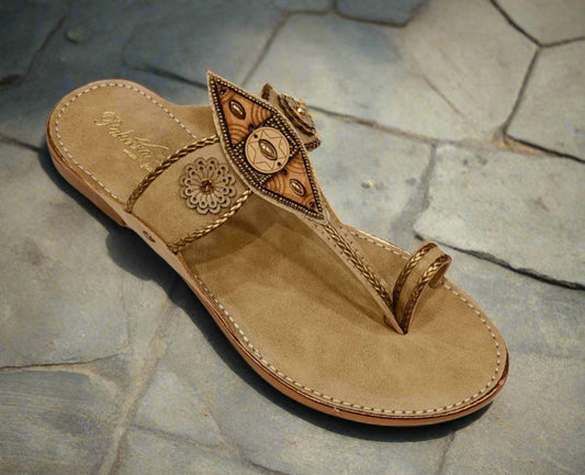 Beige sandal with decorative straps on a white background