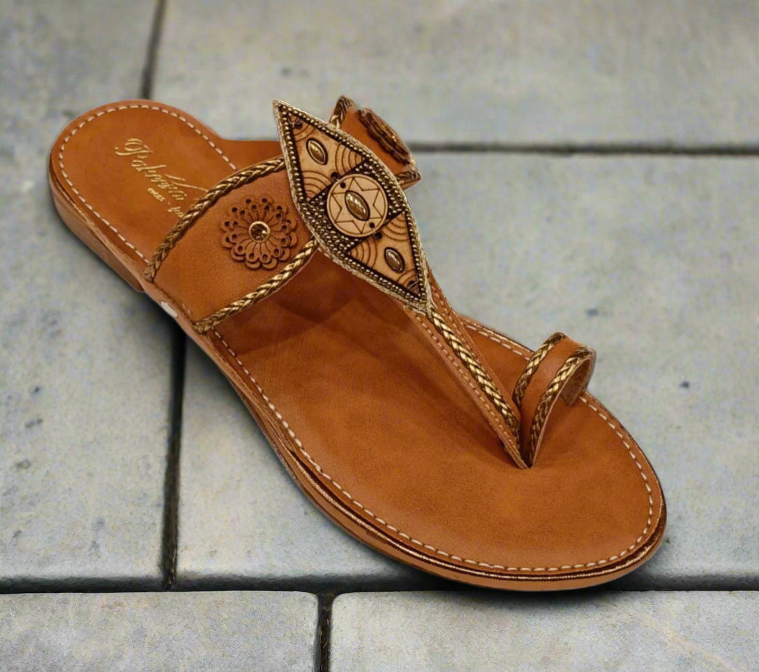 Brown sandal with decorative straps on a white background