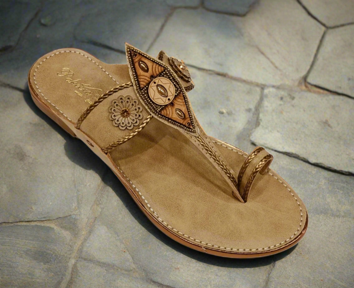 Beige sandal with decorative straps on a white background