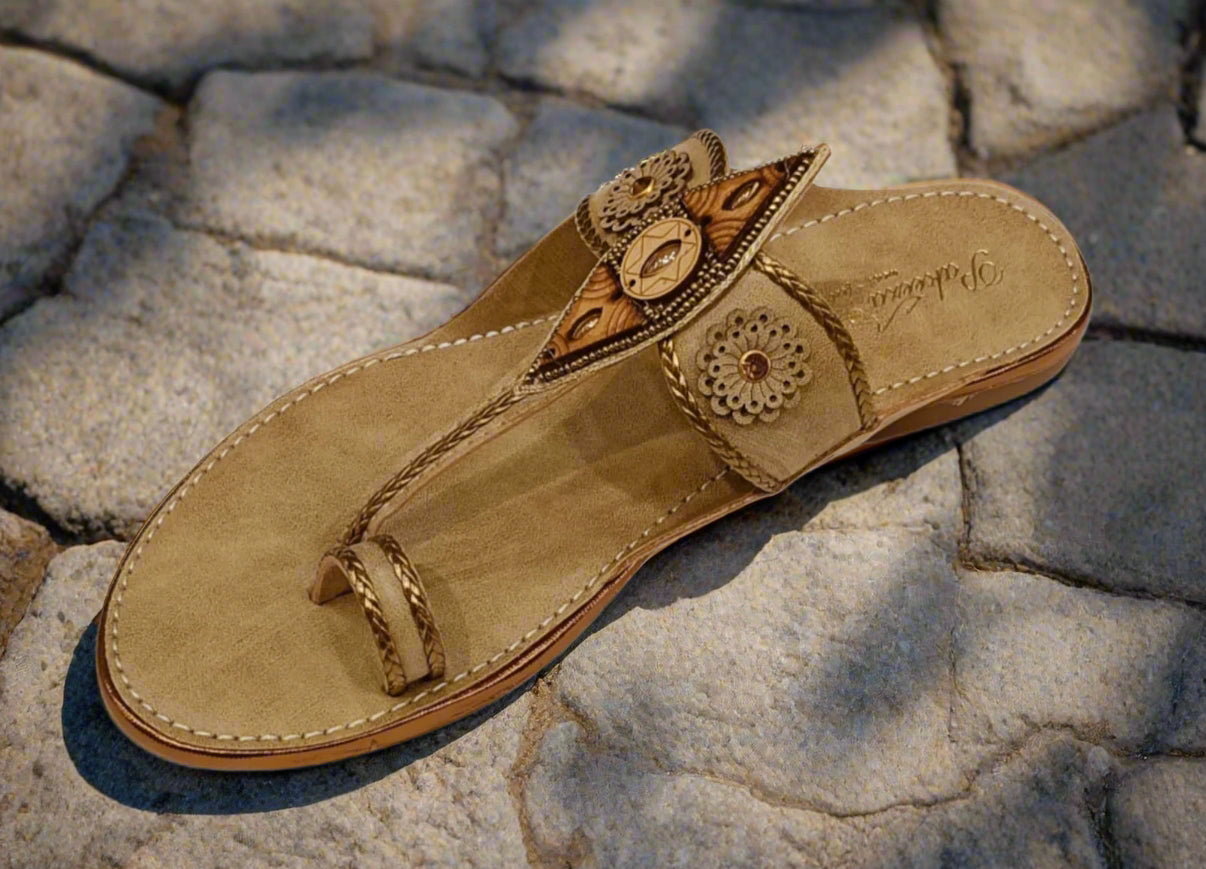 Beige sandal with decorative elements on a white background