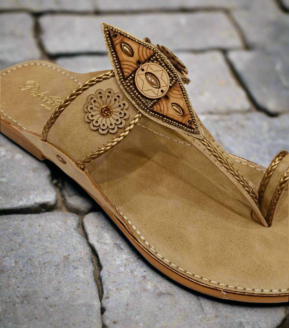 Beige sandal with decorative elements on a white background